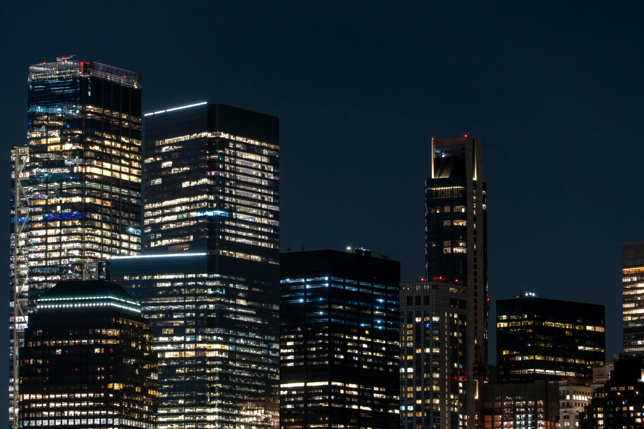 Explore the dazzling skyline of Manhattan with illuminated skyscrapers at night, showcasing New York City's vibrant architecture.